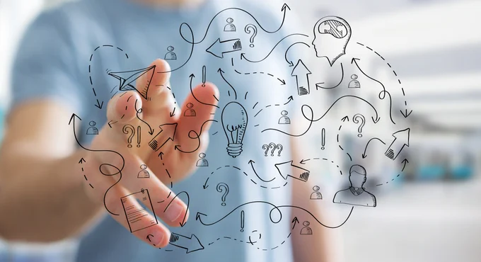 Person with their hand out in front of them. Drawings depicting innovation in the foreground.