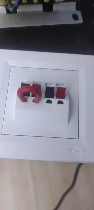 Two pairs of red and black Loudspeaker Terminals from Schneider electric with white flush mounting frame, one of them is shorted with a red wire