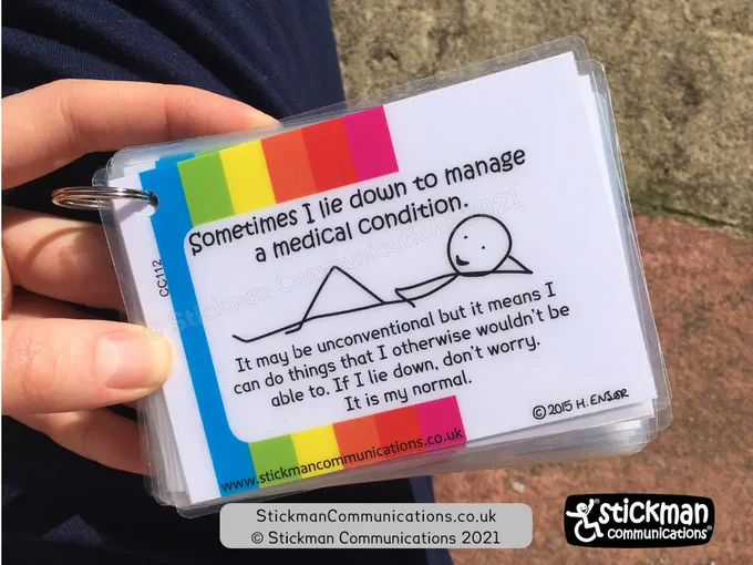 Laminated card with rainbow striped border and lounging stickman. Text "Sometimes I lie down to manage a medical condition. It may be unconventional but it means I can do things that I otherwise wouldn't be able to. If I lie down, don't worry. It is my normal."