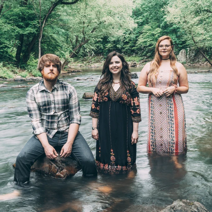 📷 of The Barefoot Movement standing knee deep in a creek. Photo by Workshop Media.