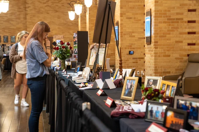 Two people looking at the Aggie Muster Reflections Display.