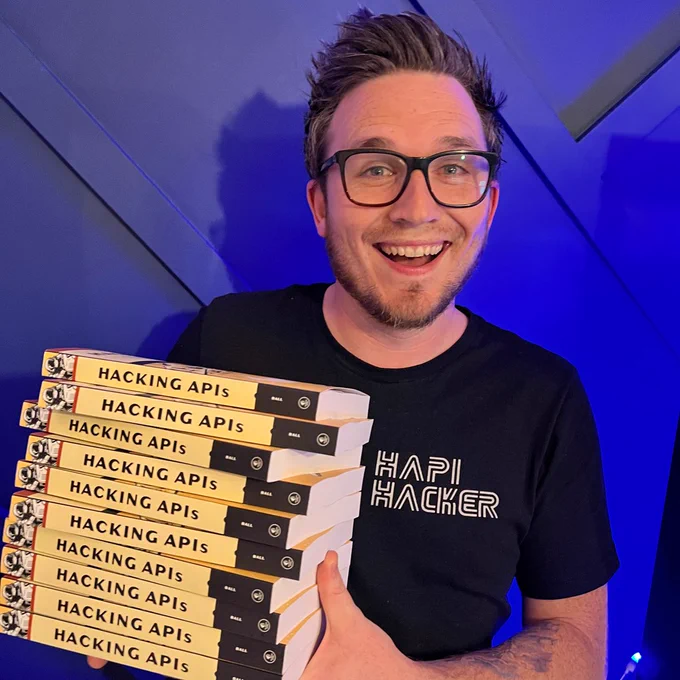 A hAPI hacker holding ten copies of Hacking APIs