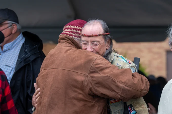 Two people hug during the dedication ceremony of markers locating where the nine students were wounded on May 4, 1970.