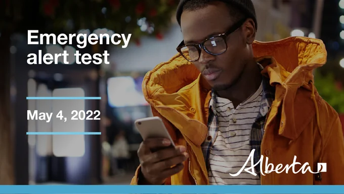 A young adult checking his phone after getting an emergency alert test.
