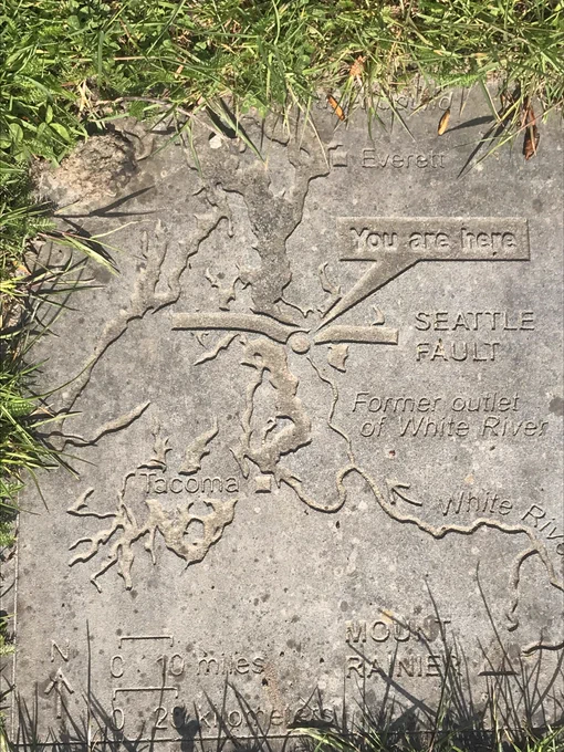 Stone carving of map of Seattle fault zone with callout pointing to fault saying ‘You are here’