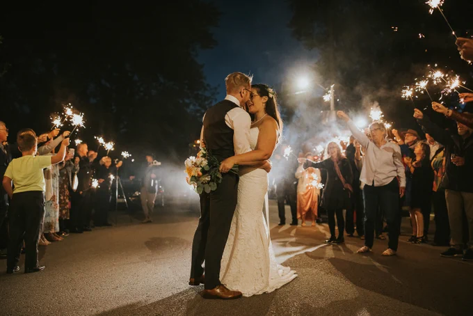 Bride and Groom dance in the street at night, with sparklers.