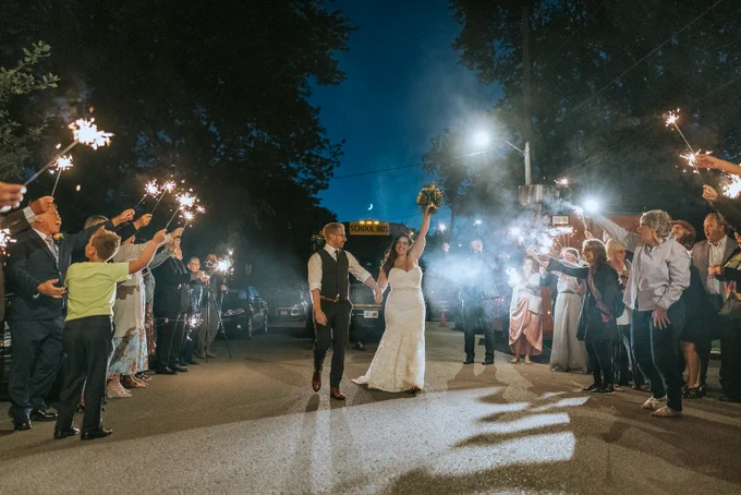 Bride and Groom celebrate in the street at night, with sparklers.