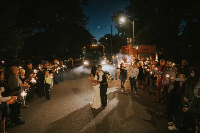 Bride and Groom dance in the street at night, with sparklers.