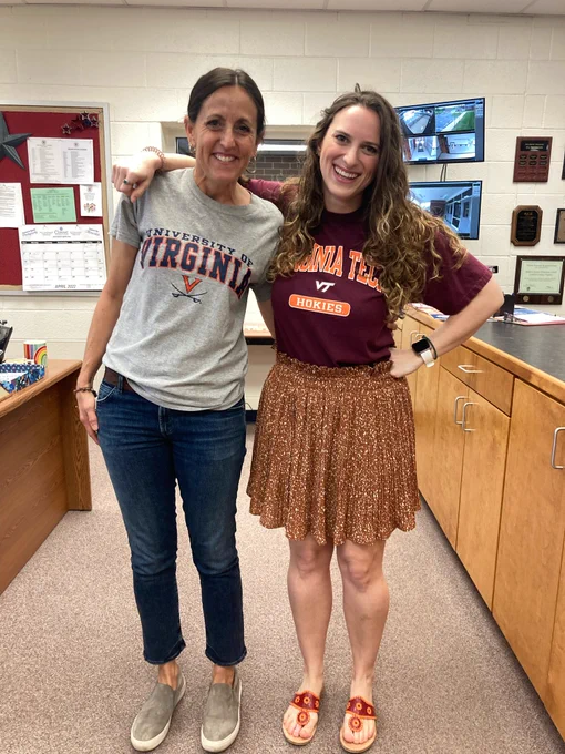 Two women smiling in UVA and VT clothes.