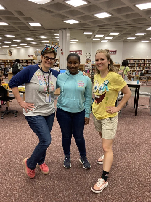 Both librarians smiling with a student also wearing Spongebob attire!