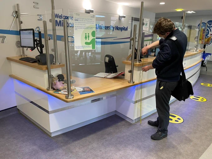 AccessAble surveyor measuring the height of the main reception desk.