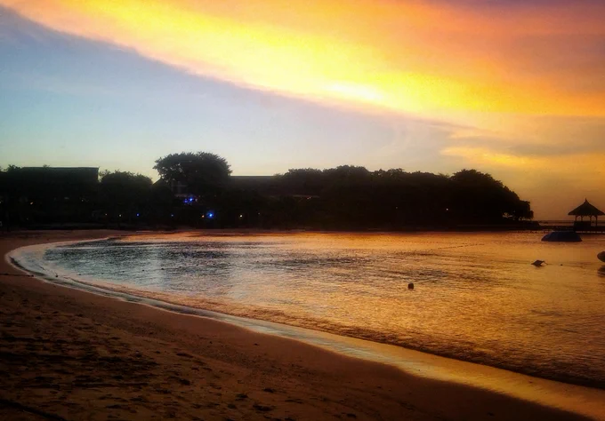 Sunset on a beach. Golden sky, golden sea.