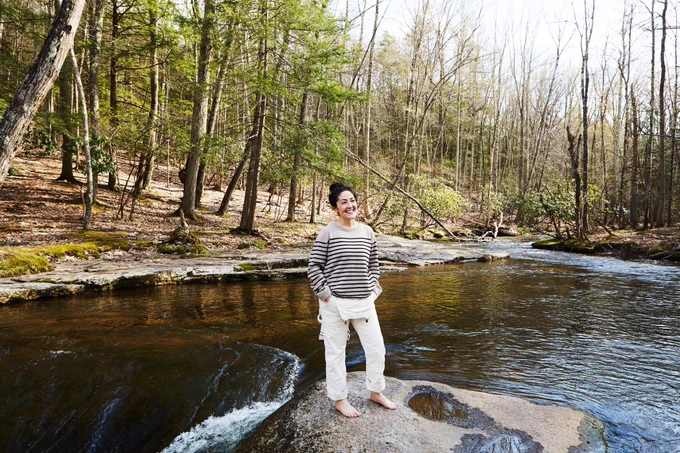 Grace Bonney barefoot on a rock in a lake