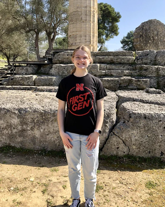 Julia standing in front of a large stone column.