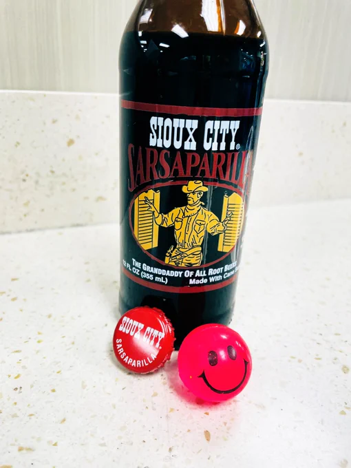 Bottle of Sioux City Sasparilla and pink smiley face super ball taken during break from job coaching at the nearby Kroger.