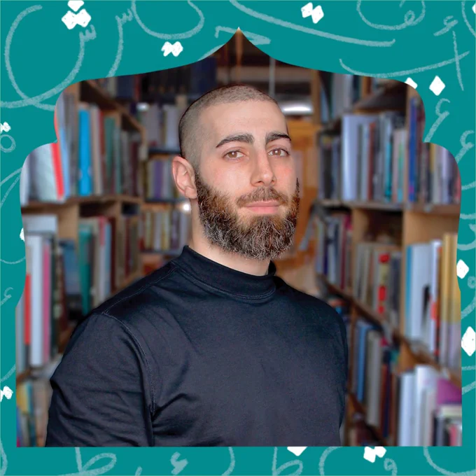 a man standing in a bookstore with shelves of books behind him 