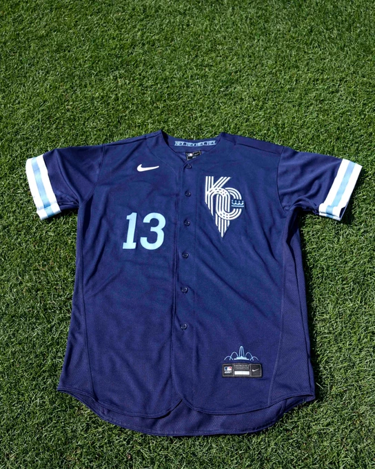 The front of a Salvador Perez City Connect jersey laying on the grass at Kauffman Stadium.