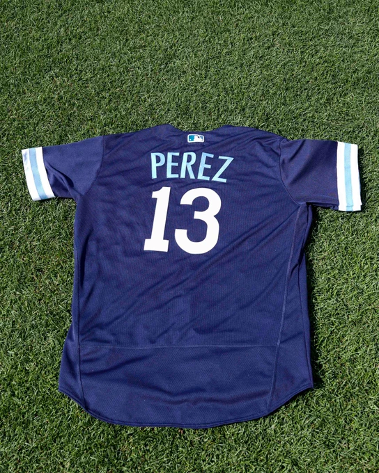 The back of a Salvador Perez City Connect jersey laying on the grass at Kauffman Stadium.