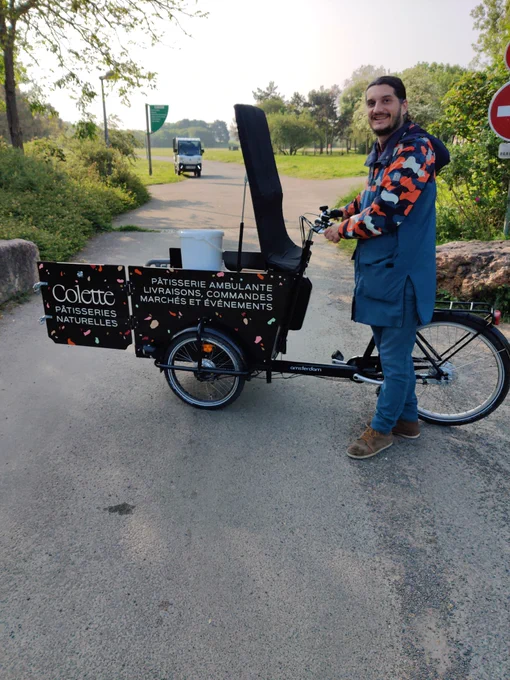 Pierre livrant avec le vélo de Colette Pâtisseries des produits locaux bio et zéro déchet pour le défi des familles zéro déchet d'Angers Loire métropole