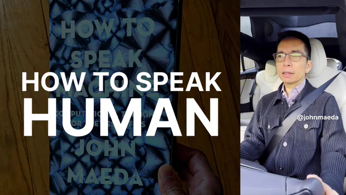 Person in car with graphic card that reads "HOW TO SPEAK HUMAN"
