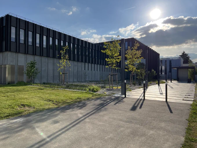 Le bâtiment de l'Institut Pascal de l'Université Paris-Saclay l'après-midi du 1er mai. Ciel bleu, peu de nuages, le soleil est confortablement assis sur eux.