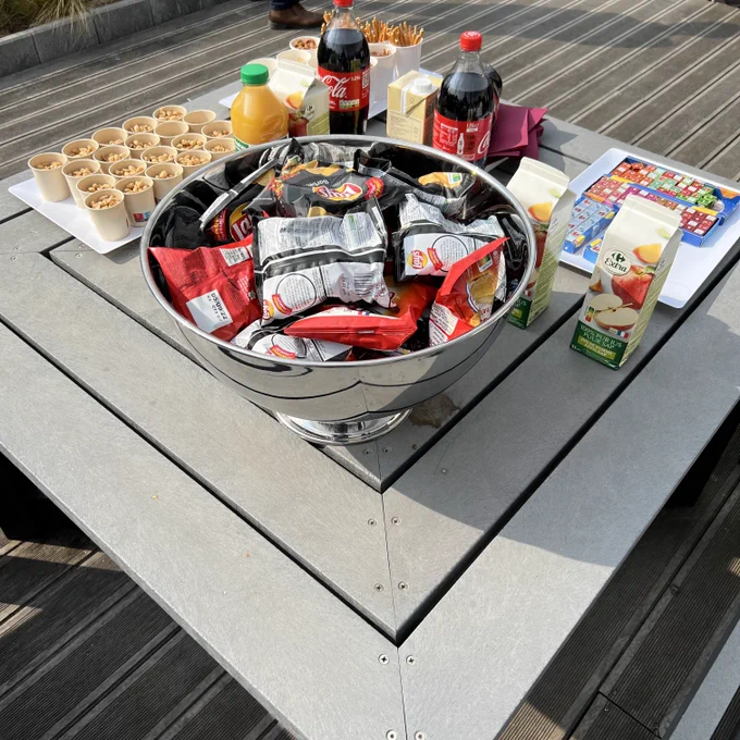 Table de post-conférence : cola, jus de fruits, chips, cacahuètes, sticks au sel, fromage