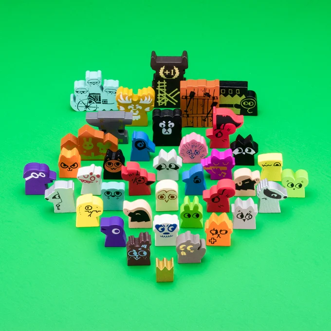 Wood meeples and components from the Root game family are laid out in a symmetrical pattern on a green surface.