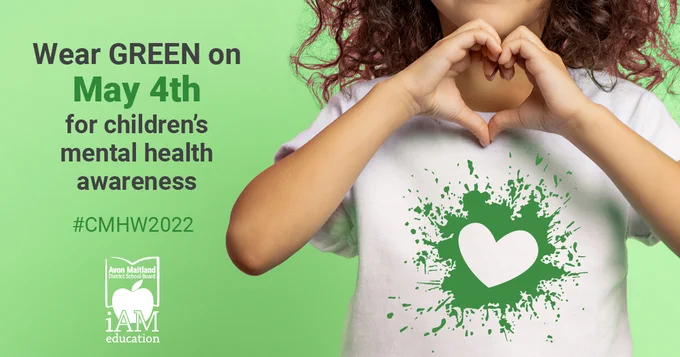 Wear green on May 4th for children's mental health awareness. #CMHW2022. AMDSB logo in white. Image of child wearing a white t-shirt with a green heart silhouette, holding hands together in a heart.