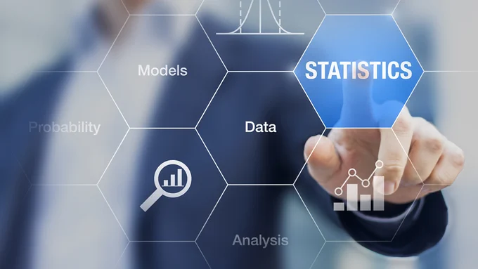 A person pressing a button on a touch screen with the word "statistics" on it.