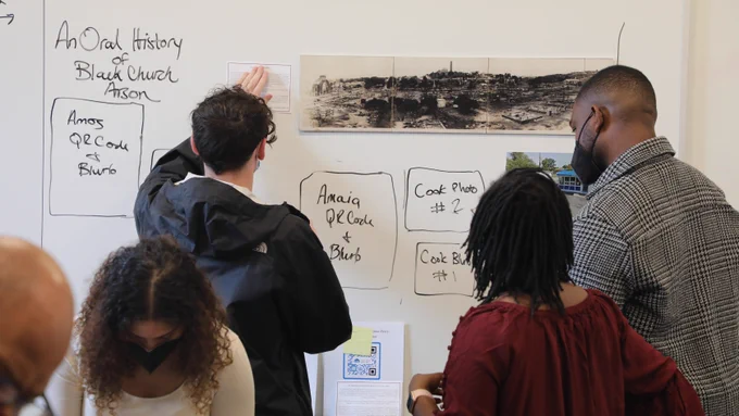 Students in HDS Professor Todne Thomas's class, "Black Church Burning," work on laying out items for a library exhibit they created.