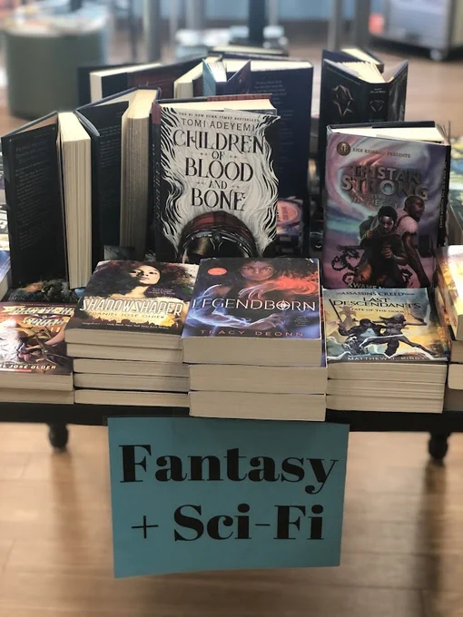 Table marked Fantasy and Sci-Fi with amazing titles like Shadowshaper, Children of Blood and Bone, and Tristan Strong.