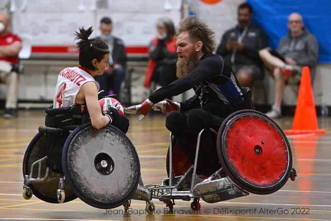 Erika Schmutz (The first women to represent Canada at the Paralympics in Wheelchair Rugby) takes a big hit from Andrew Davis, both the backs of their chairs go up in the air. 