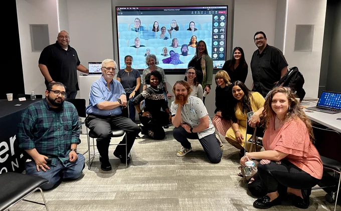 Small group of teachers in front of virtual teachers on a screen