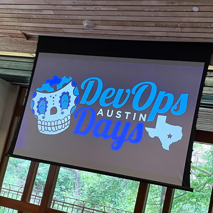 DevOpsDays Austin logo on the projector in the main ballroom.