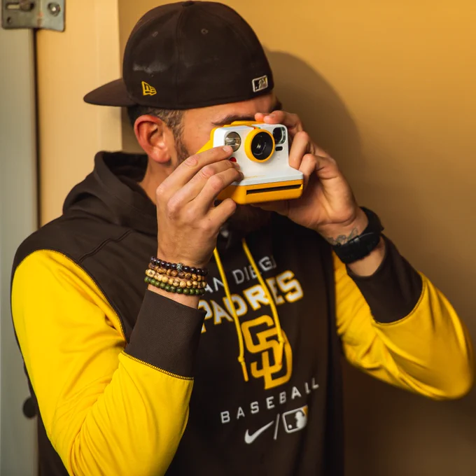 Joe Musgrove taking a photo with a Polaroid camera.