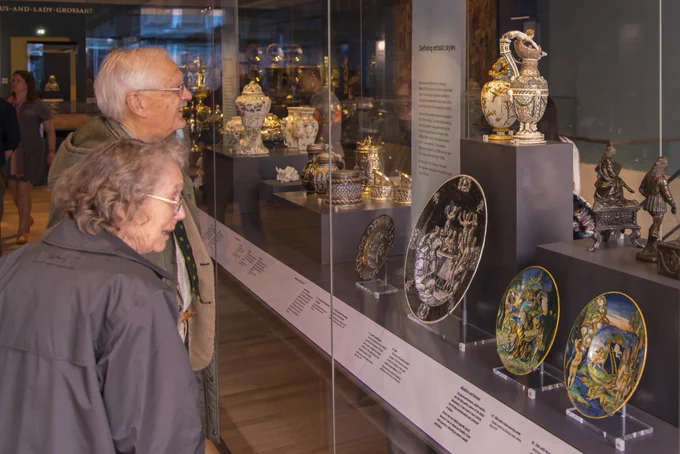 Two people looking at artefacts protected by a glass cabinet