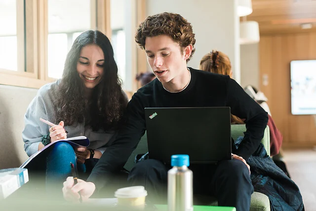 Two students work together on an old exam paper in the Student Centre.