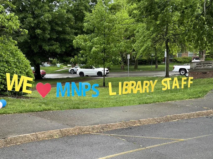 A sign that says we love our library staff.