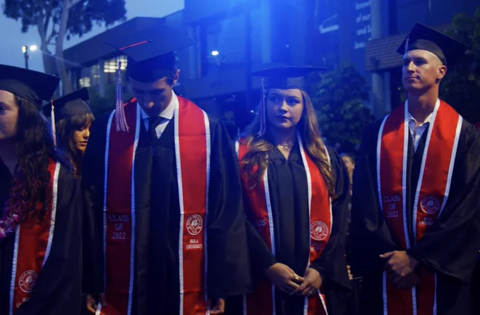 Graduates standing at ceremony.