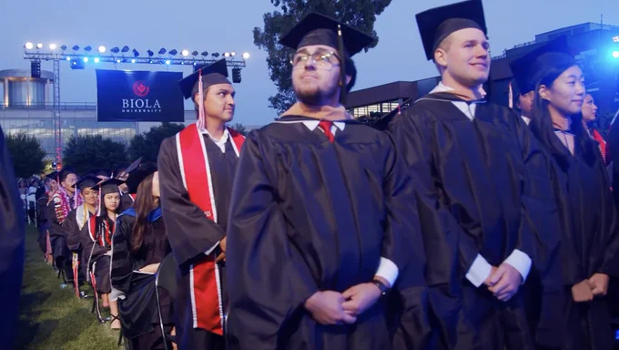 Graduates standing at ceremony.