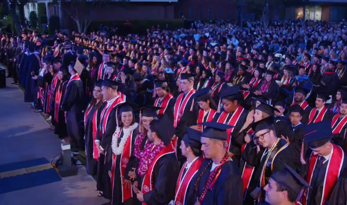 Graduates standing at ceremony.