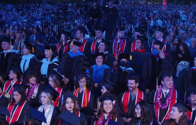 Graduates standing at ceremony.