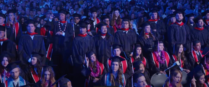 Graduates standing at ceremony.