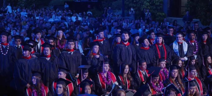 Graduates standing at ceremony.
