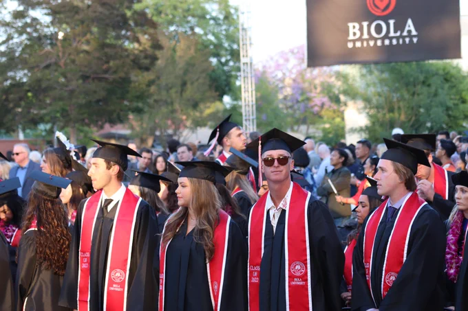 Graduates standing at ceremony.