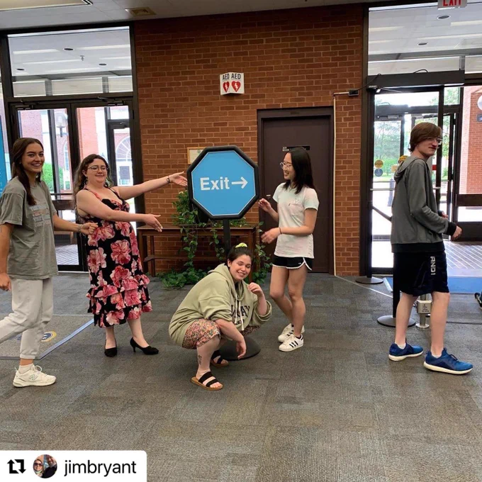 Five students standing by a sign they designed