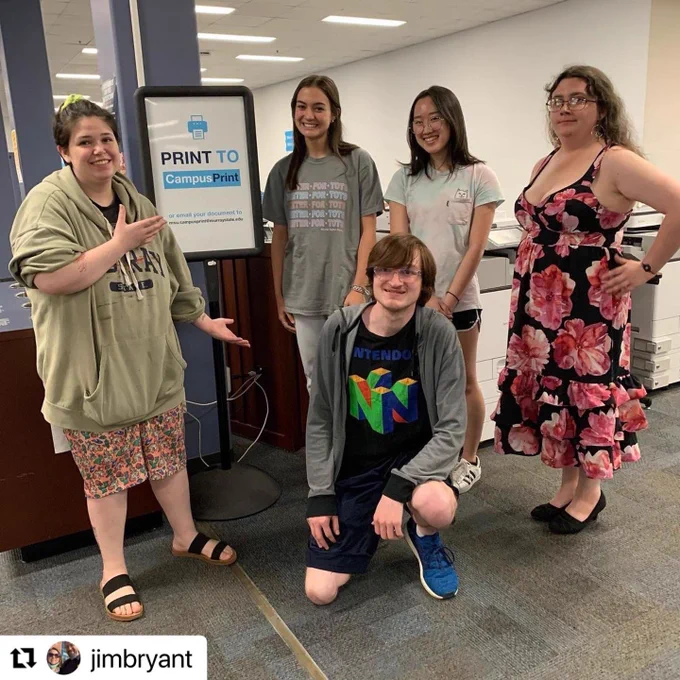 Five students standing by a sign they designed