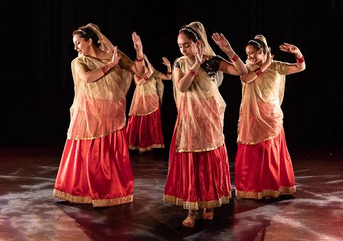 Four volunteers dance in traditional Indian costume