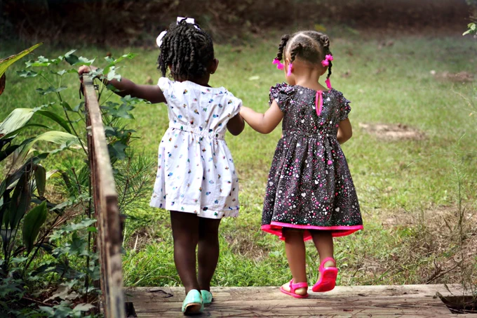 Two young girls holding hands