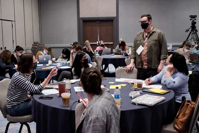 Andy Welfle chats with a table during the Writing is Designing workshop.
